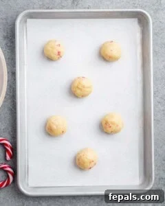 cookie dough balls placed on a sheet pan before baking.