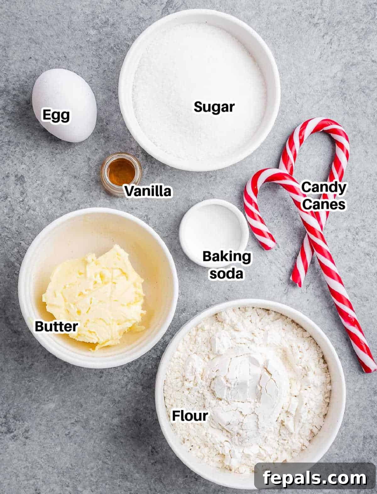 A collection of fresh ingredients laid out, including butter, sugar, flour, and candy canes, ready to be transformed into peppermint cookies.