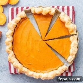 Sweet potato pie with several clean slices cut, showing the creamy orange filling and flaky crust.