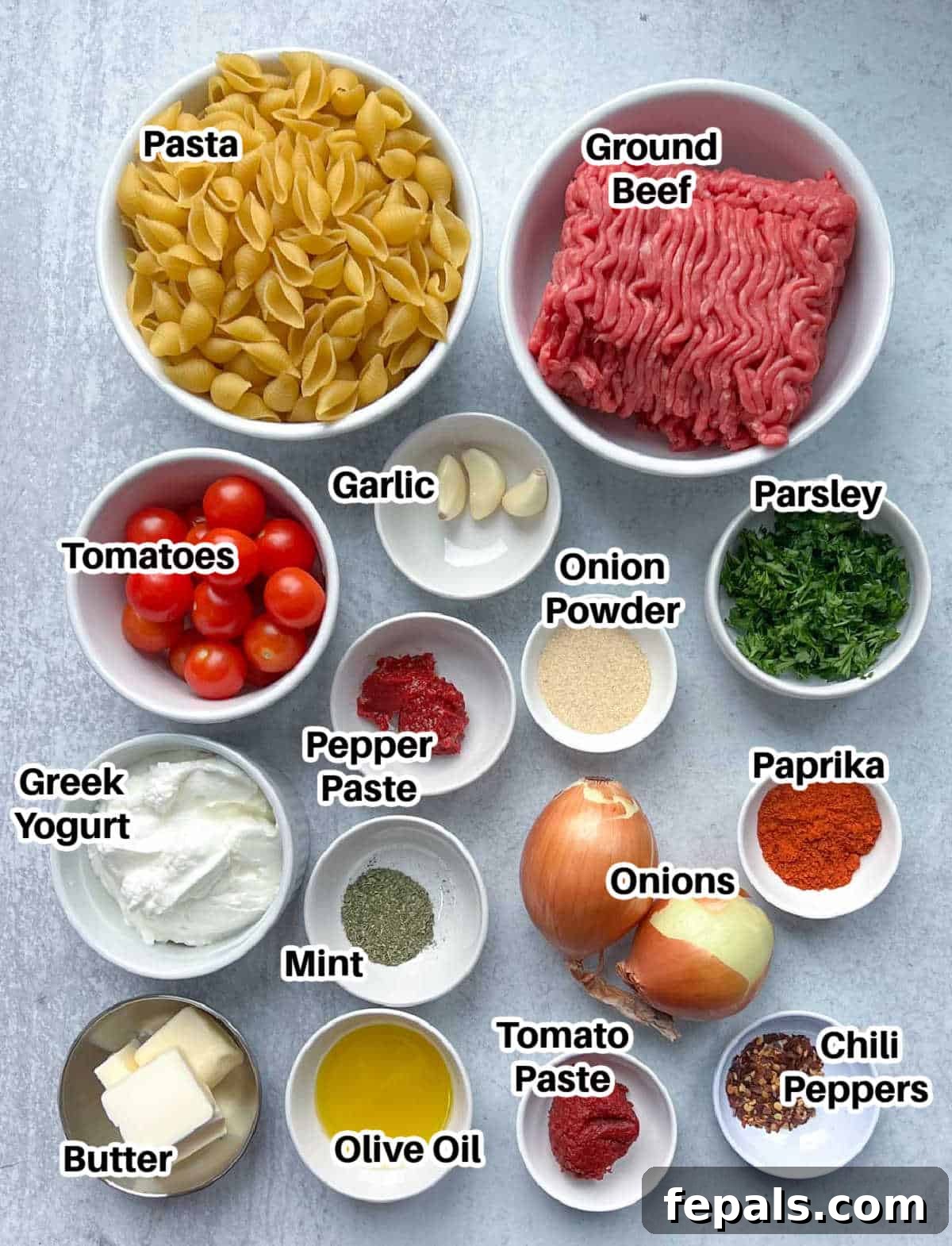 A curated display of all essential ingredients needed to prepare the delicious Turkish pasta, including pasta, ground beef, yogurt, spices, and fresh garnishes.