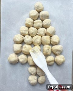 Egg wash is brushed over the cheese ball dough.