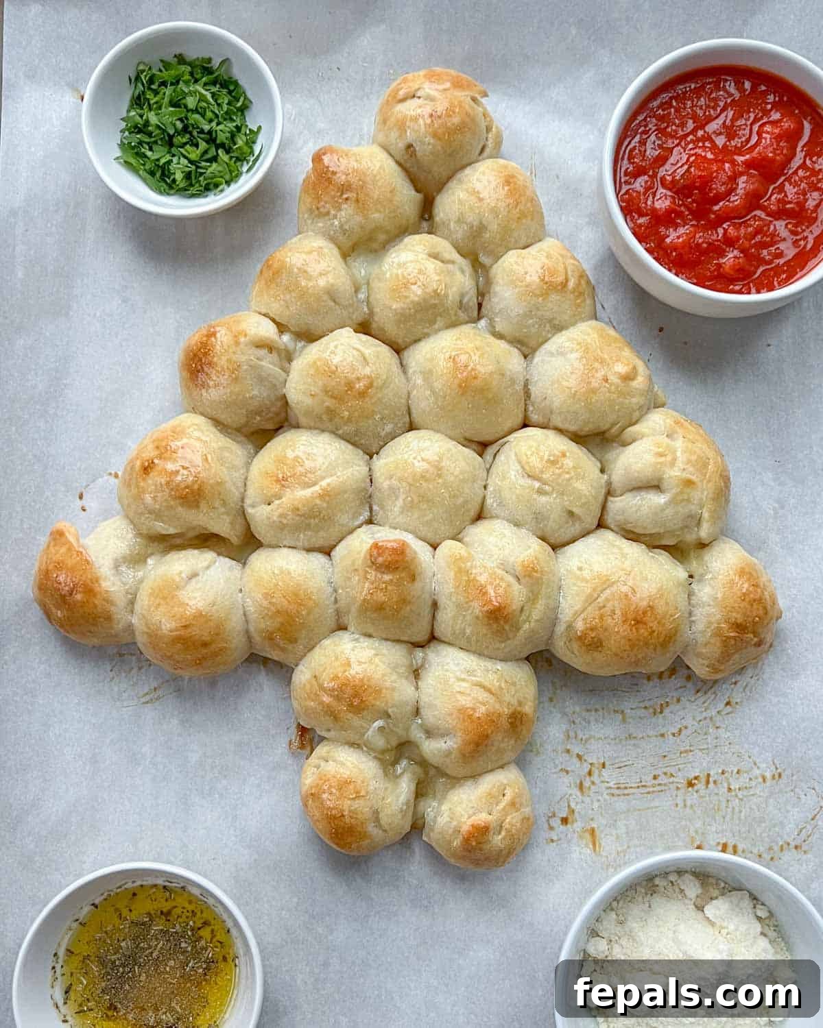 The baked Christmas tree pull-apart bread, golden brown and puffed, cooling on a sheet pan after being removed from the oven.