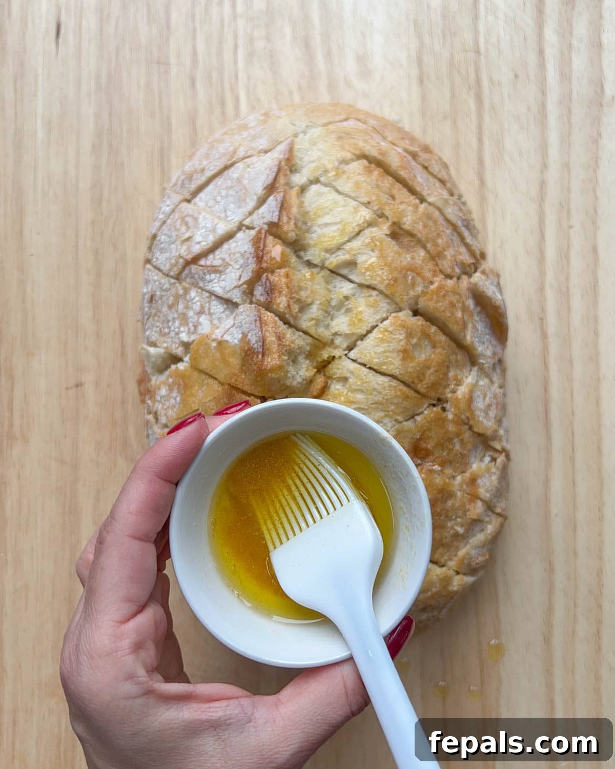 a bowl of oil over the bread and brush to rub oil on the bread.