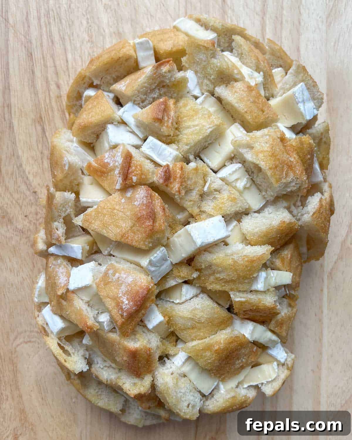 brie cheese added to slits of bread.