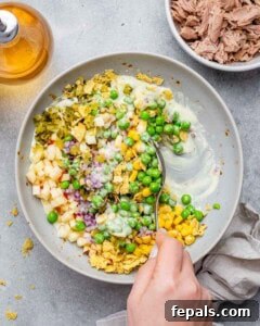 The McConaughey Tuna Salad That Broke the Internet 13 Spoon mixing ingredients into creamy dressing in a bowl for the fish salad.