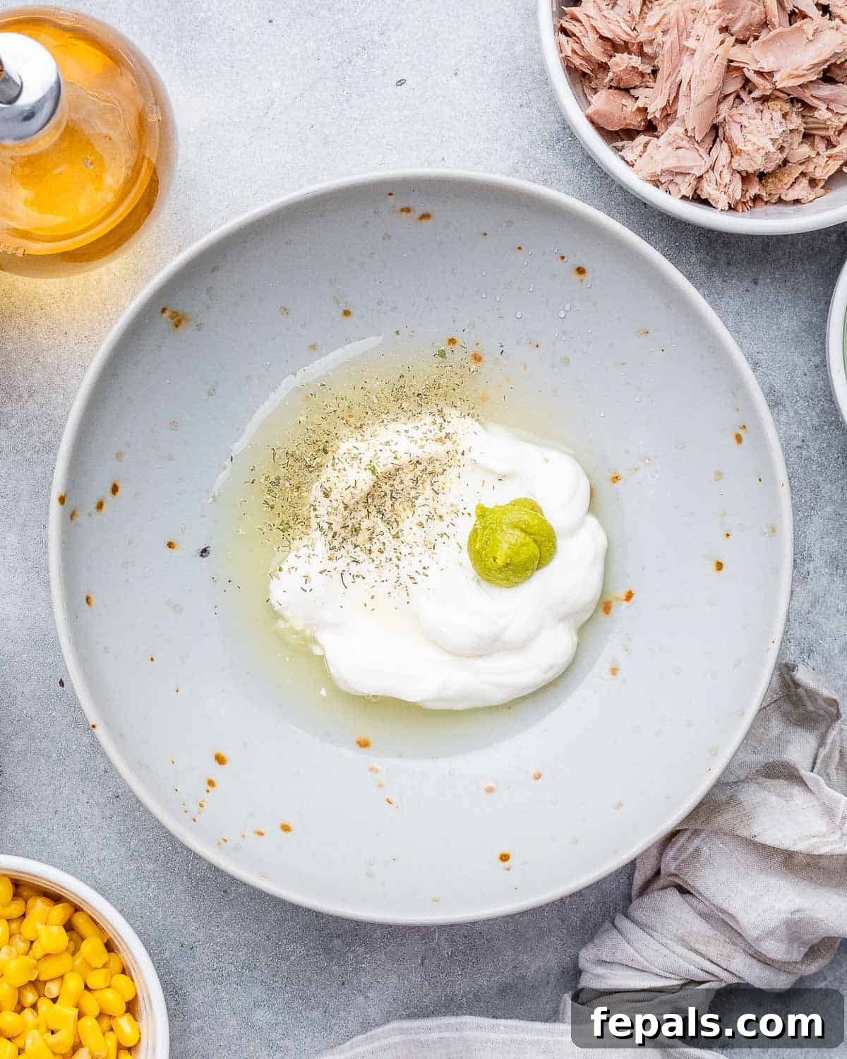 The McConaughey Tuna Salad That Broke the Internet 4 Small bowl showing mayonnaise, lemon juice, white wine vinegar, wasabi paste, and Italian seasoning combined, ready for whisking.