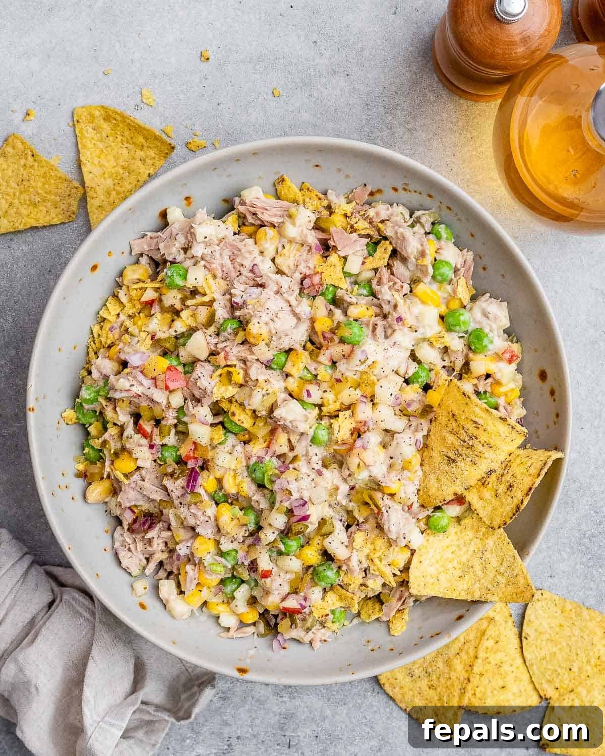The McConaughey Tuna Salad That Broke the Internet 8 A serving of the prepared tuna salad presented in a stylish gray bowl, accompanied by a scattering of tortilla chips for dipping.