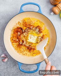Garlic, butter, and crushed chili flakes melting together in a hot skillet to build the sauce base.
