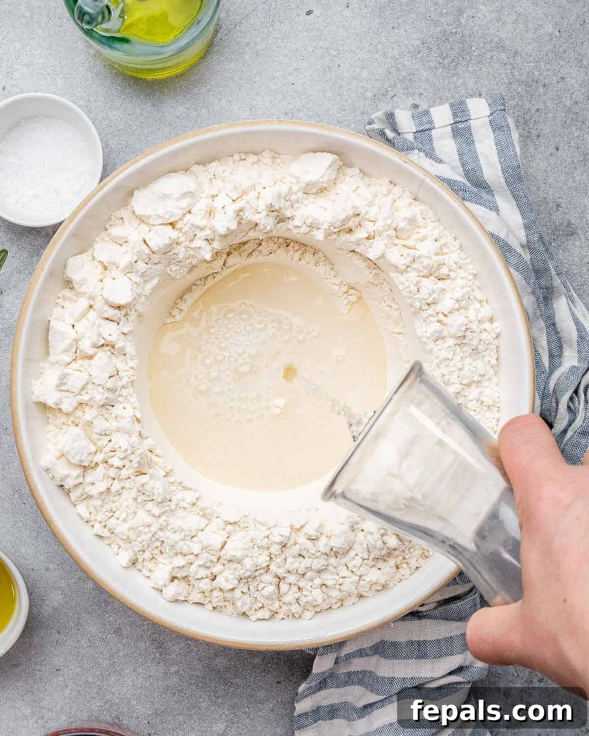 Perfect Italian Focaccia At Home 5 Pouring activated yeast into flour for focaccia dough.