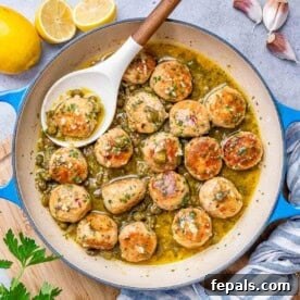 chicken meatballs in a lemony sauces in a skillet with spoon in skillet.