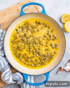 Capers and lemon juice simmering in a pot.