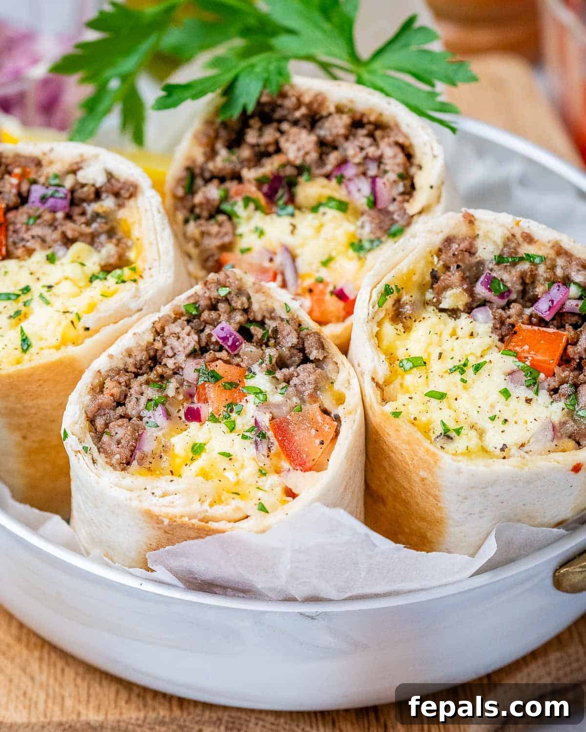 4 burritos cut in half facing up on a plate.