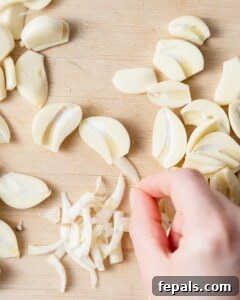 Fluffy Lebanese Garlic Dip 15 fresh garlic sliced on a cutting board.