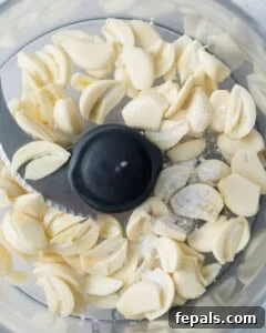 Fluffy Lebanese Garlic Dip 16 Sliced garlic placed in a food processor.