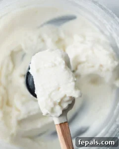 Fluffy Lebanese Garlic Dip 20 spatula with garlic sauce over a food processor.