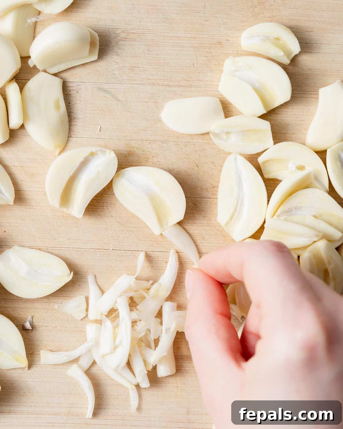 Fluffy Lebanese Garlic Dip 4 Fresh garlic cloves, peeled and gently sliced on a cutting board, ready for the food processor.