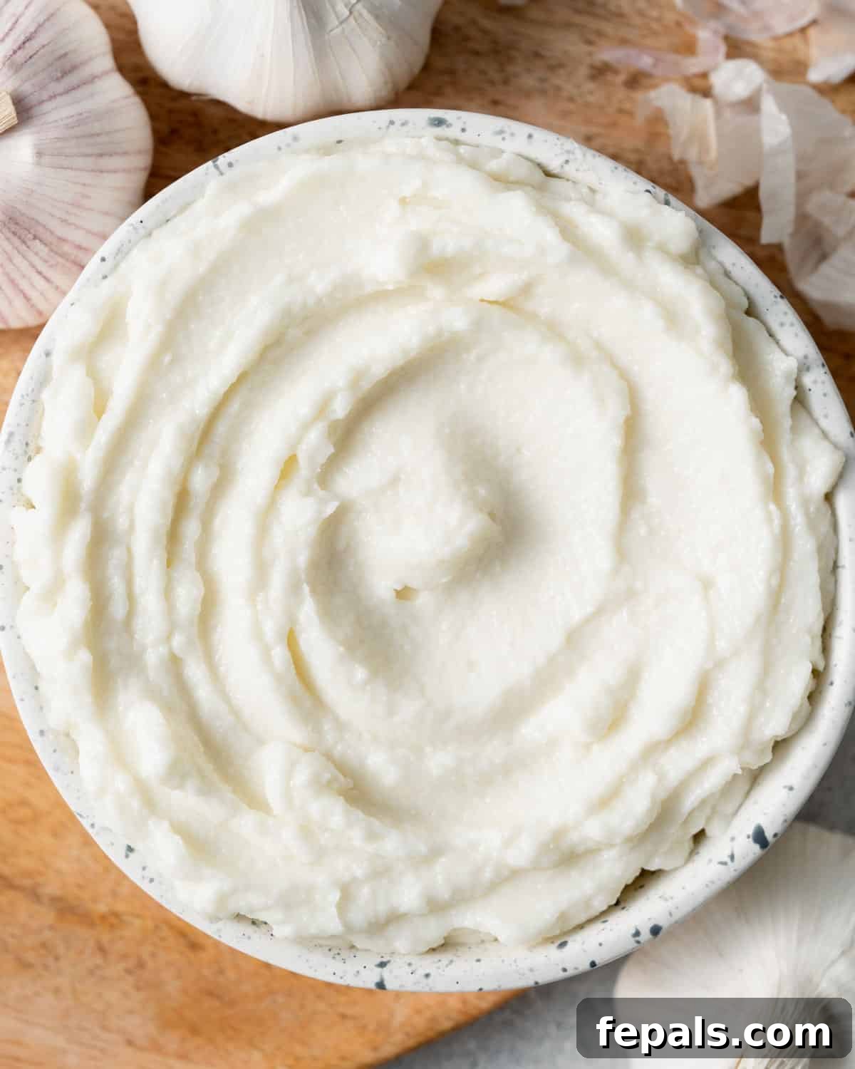 Fluffy Lebanese Garlic Dip 10 A round white bowl filled with freshly made, smooth Lebanese garlic sauce (Toum), ready to be served.