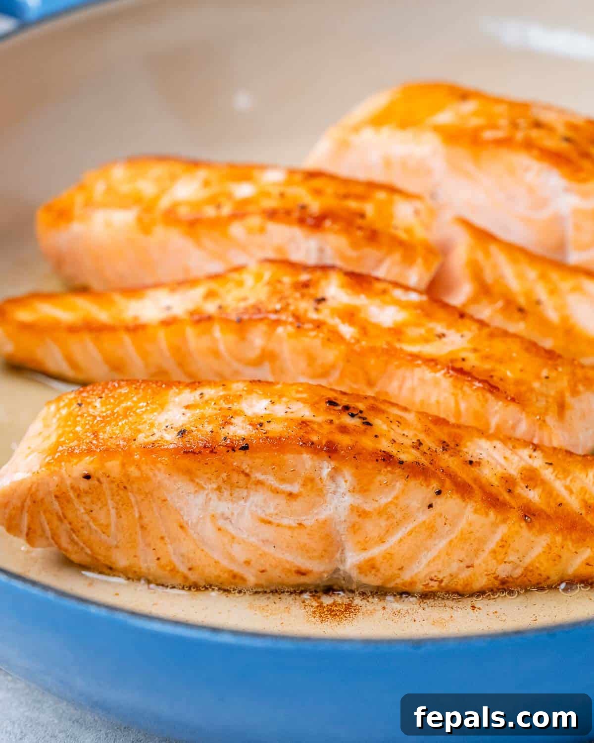Decadent Salmon Alfredo 4 Fried salmon in a blue pan.