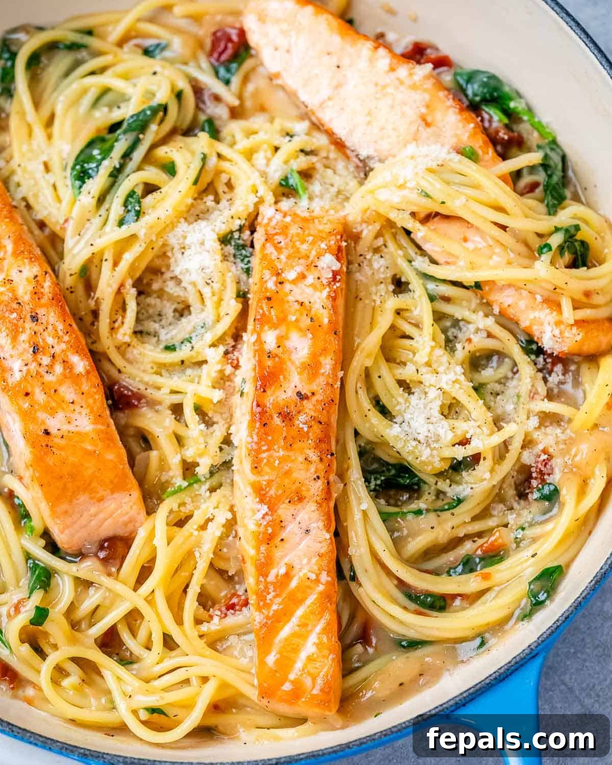 Decadent Salmon Alfredo 9 A plate with pasta, cream sauce, and fried salmon on top.