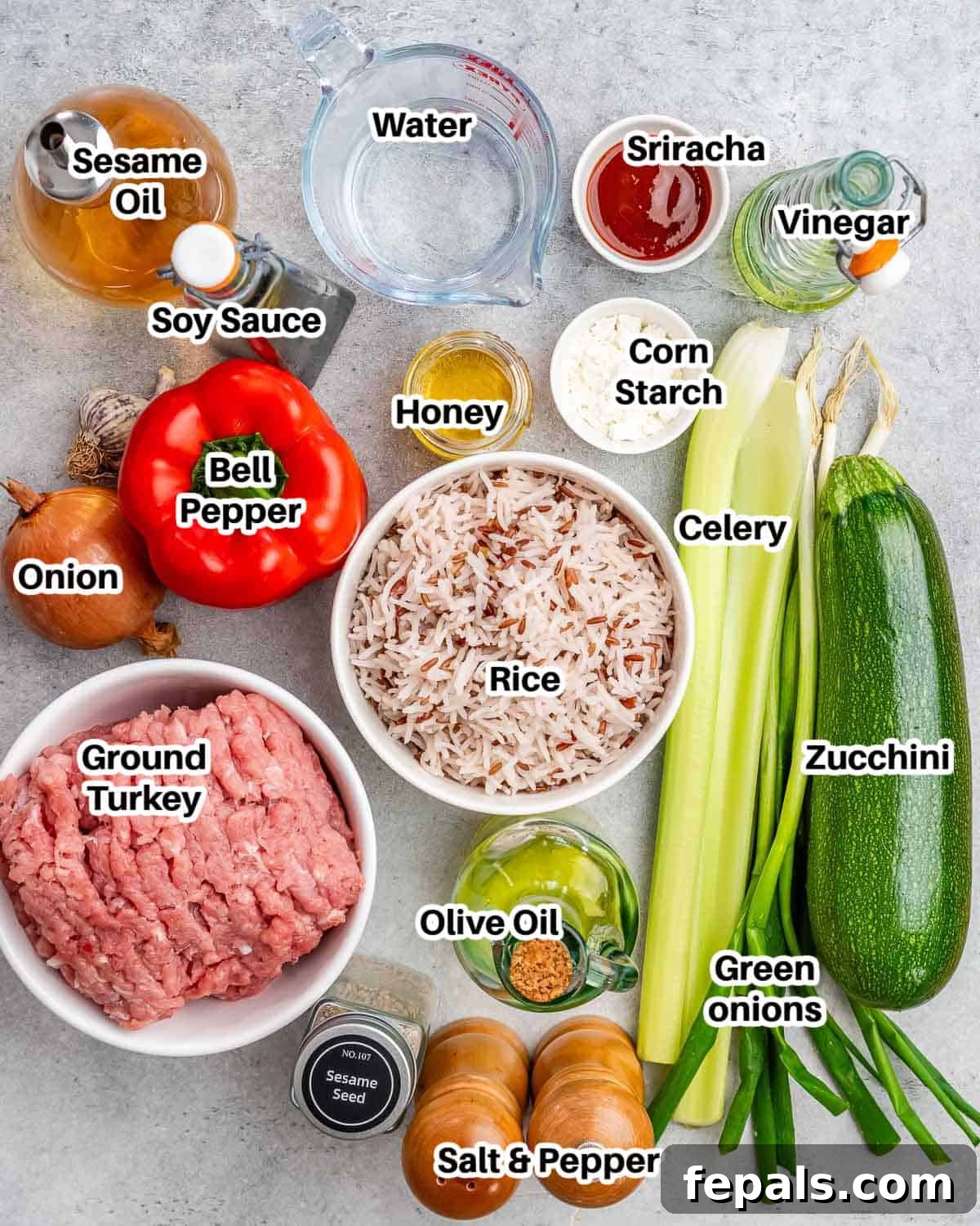 Fresh ingredients laid out on a wooden cutting board, including ground turkey, red bell pepper, zucchini, celery, onion, garlic, and sauces, ready for the stir fry.