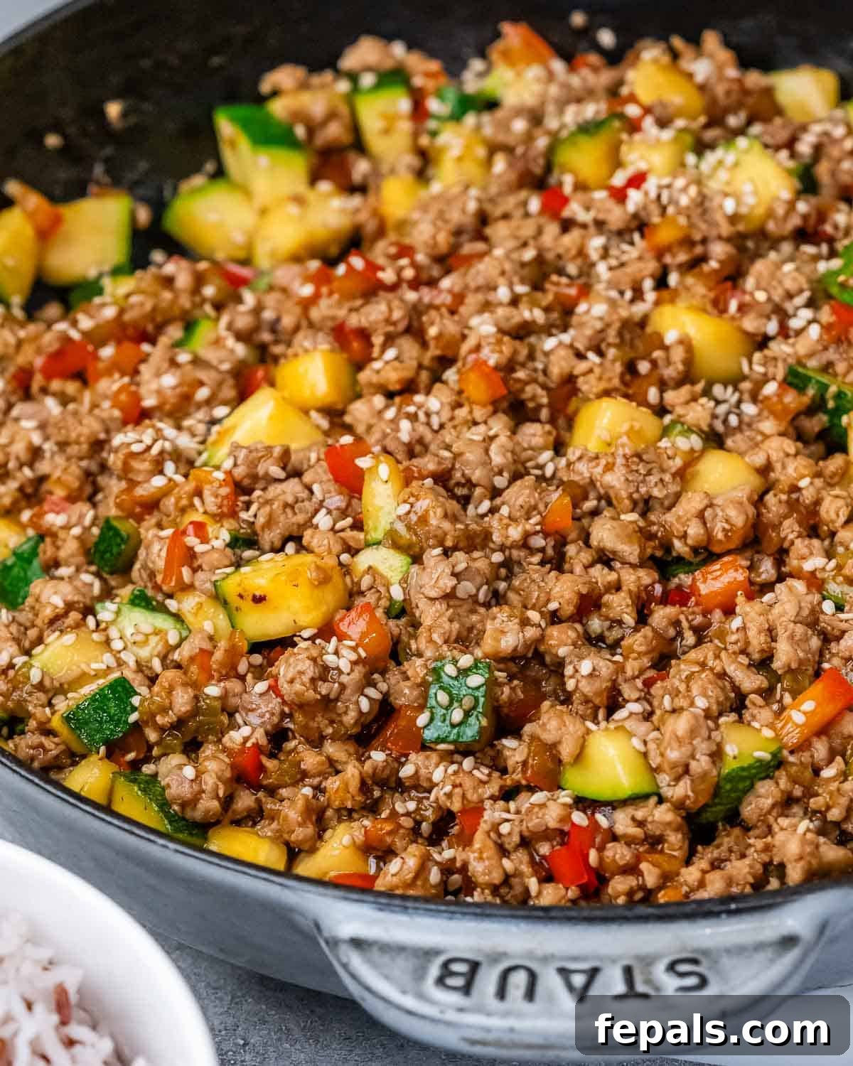 A close-up view of the finished Ground Turkey Stir Fry, glistening with sauce and vibrant vegetables, still in the skillet.