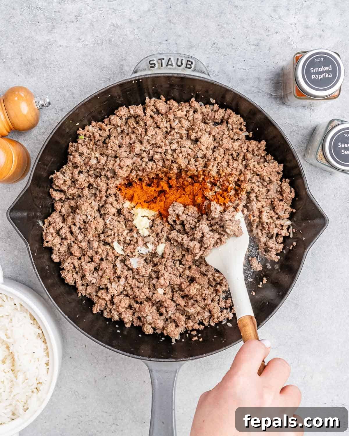 Hearty Beef & Rice Medley 6 Stirring in spices to ground beef in a skillet.