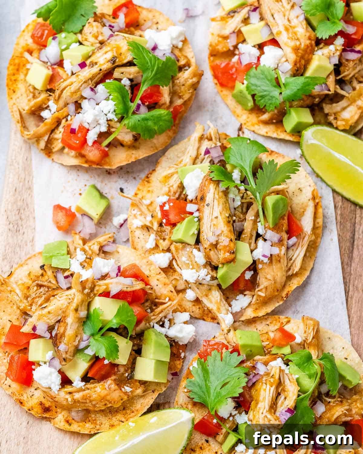Fiesta Chicken Tostadas 9 A cutting board laden with two vibrant chicken tostadas, garnished with fresh cilantro and avocado, ready to be enjoyed as a quick and healthy meal.