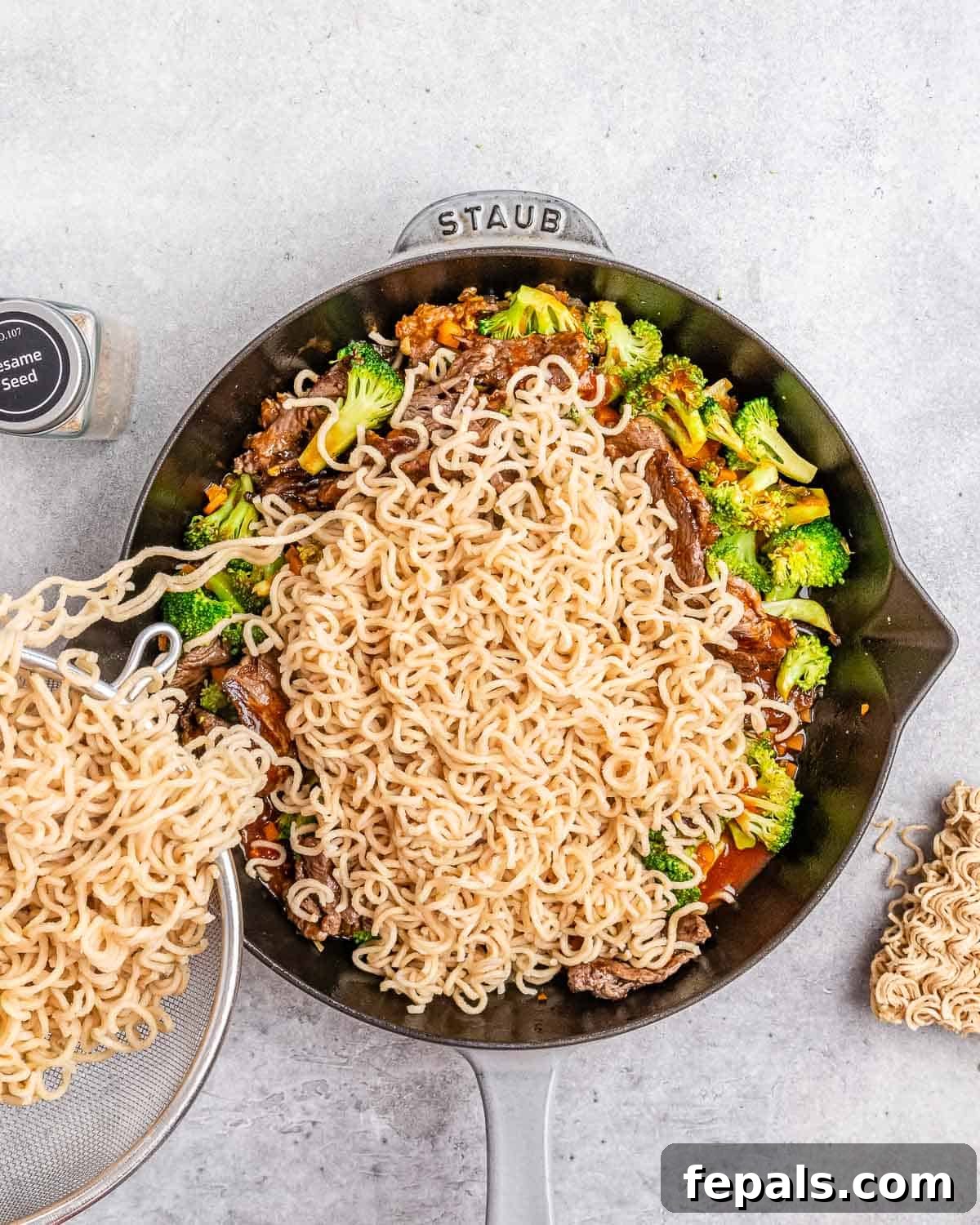 Wok-Tossed Beef Noodles 8 Cooked noodles being added to the skillet with the beef, vegetables, and sauce, ready to be tossed.