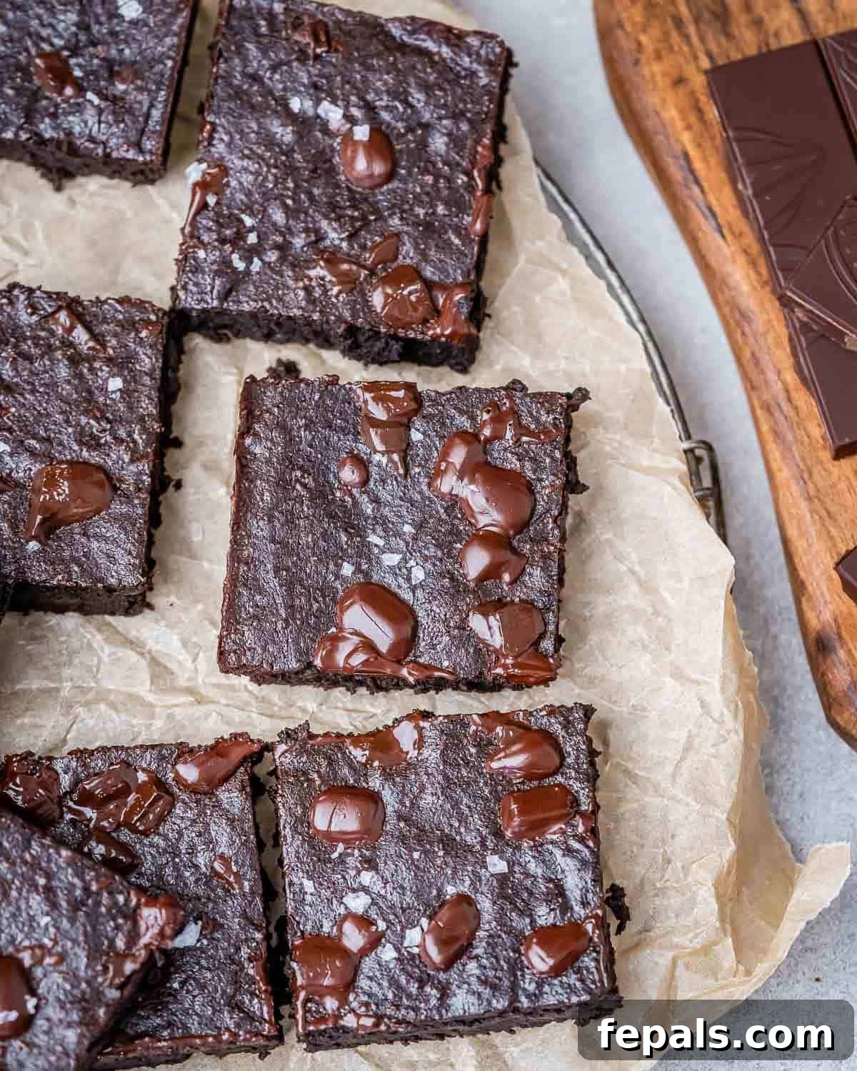 Fudgy Almond Flour Brownies 2 Fudgy almond flour brownies cut into squares on parchment paper.