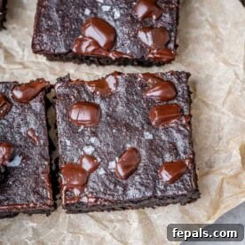 brownie squares on a parchment paper on a cutting board.