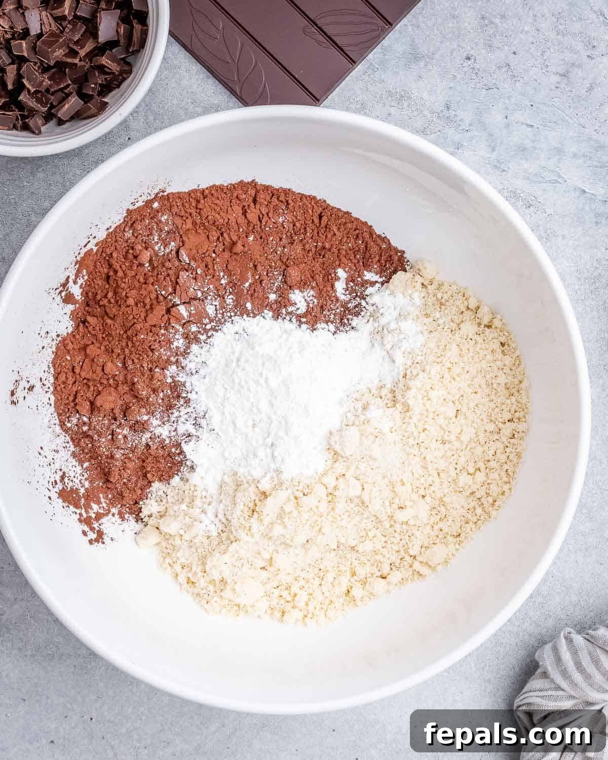 Fudgy Almond Flour Brownies 4 Almond flour, cocoa powder, and corn starch being combined in a mixing bowl.