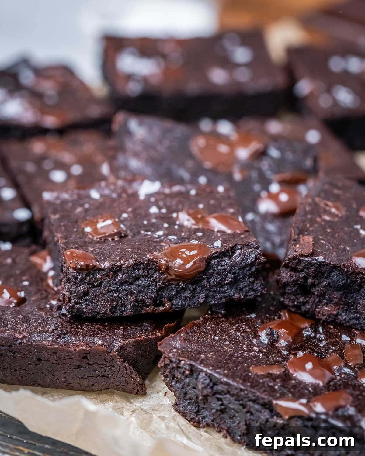 Fudgy Almond Flour Brownies 9 Stacked almond flour brownies on parchment paper, ready to be served or stored.