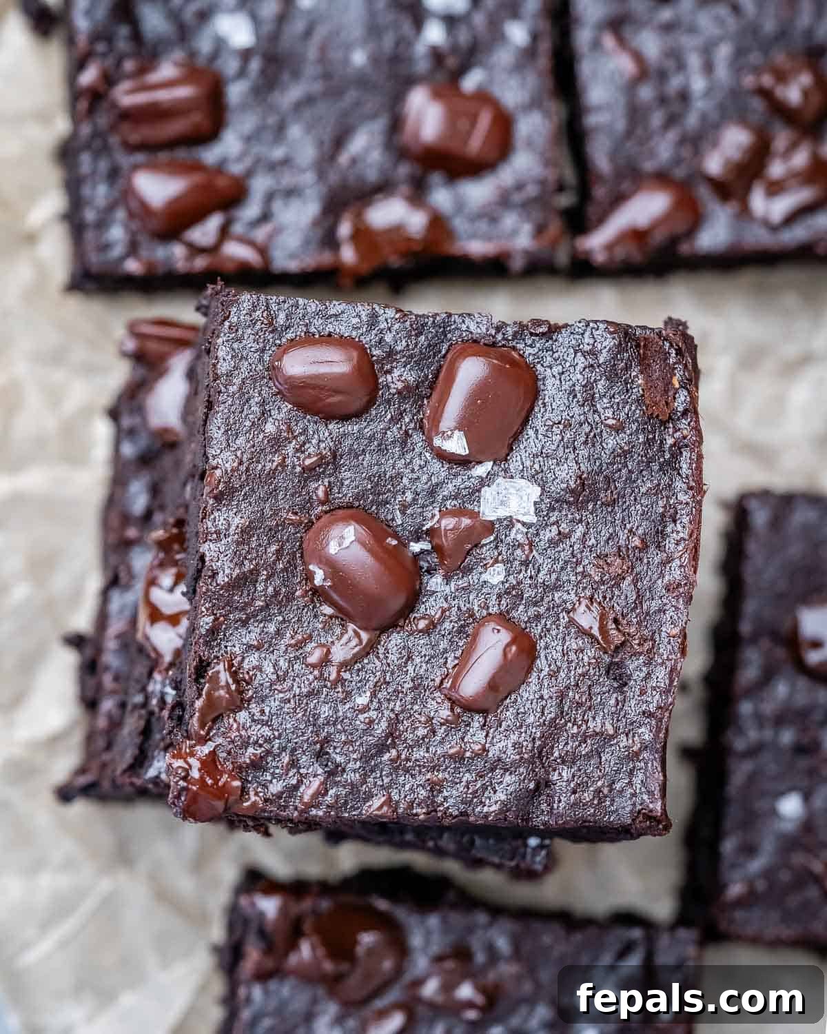 Fudgy Almond Flour Brownies 10 Neatly stacked fudgy almond flour brownies on parchment paper, ready to be enjoyed.