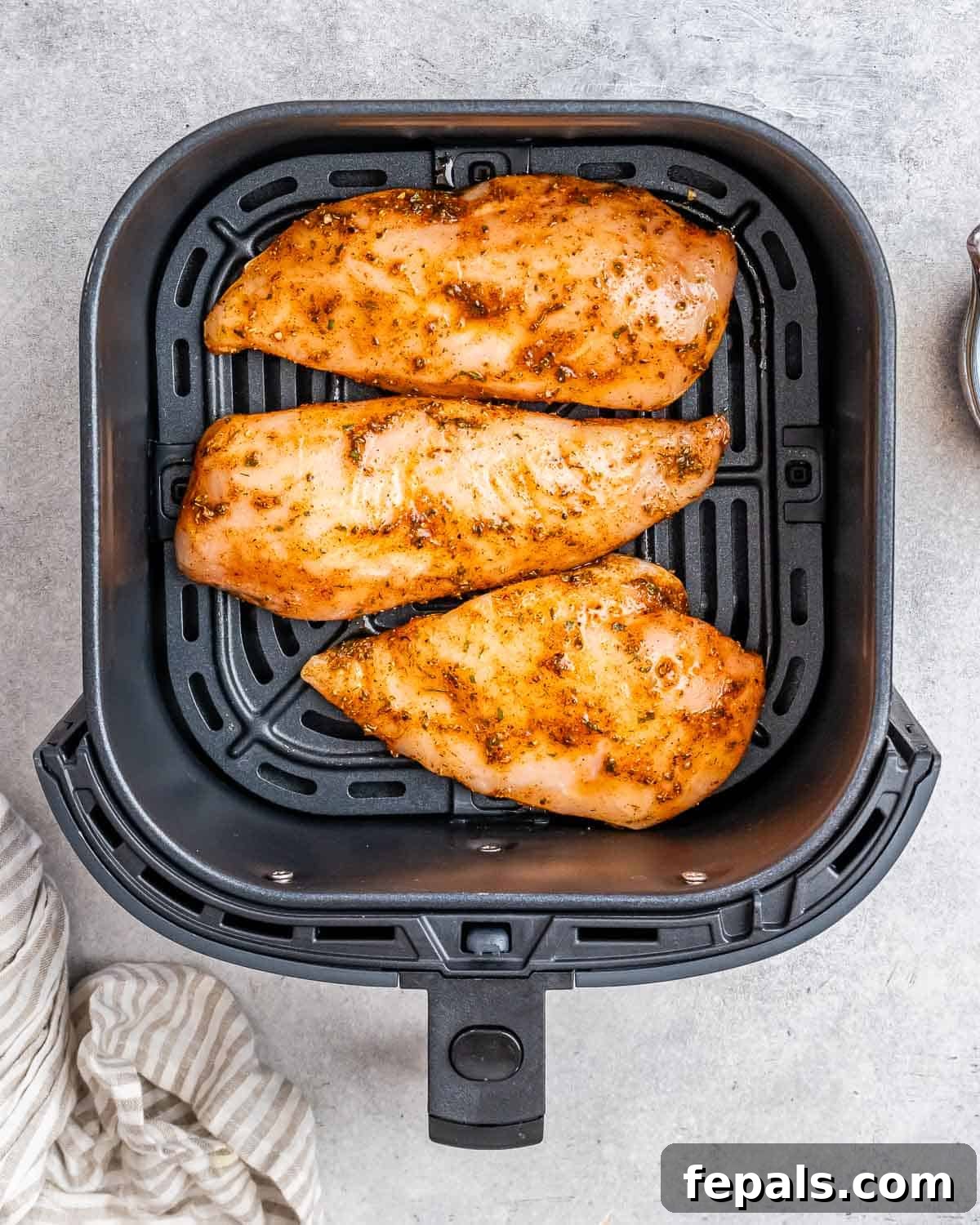 Air Fryer Frozen Chicken Breast Magic 5 Three chicken breasts in an air fryer basket.