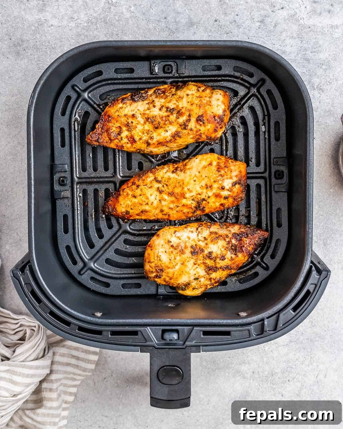 Air Fryer Frozen Chicken Breast Magic 6 Three chicken breasts in an air fryer basket.
