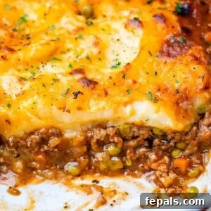 Homestyle Beef Shepherd's Delight 17 Shepherds pie in a white baking dish with meat showing at the bottom and potatoes on top.