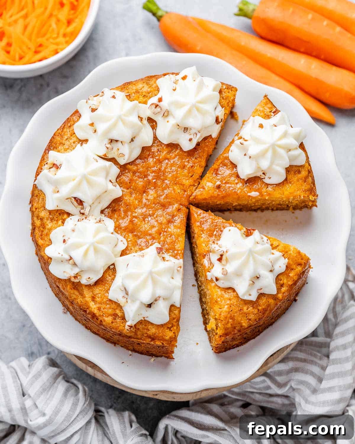 Effortless Carrot Cake 2 A round, perfectly frosted carrot cake with a slice removed, revealing its moist interior. Topped with creamy cheese frosting.