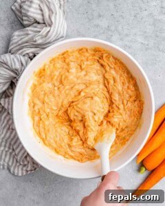 Effortless Carrot Cake 16 A spatula stirring cake batter.