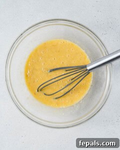 Banana and egg mixture in a bowl.
