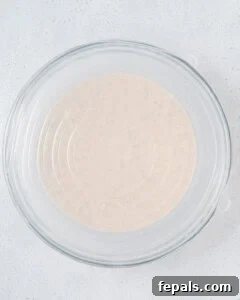 Bowl of oats covered with plastic wrap to be stored in the fridge.