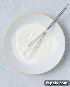 Whisk stirring yogurt in a bowl.
