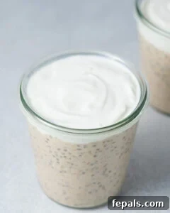 Overnight oats in a jar topped with a smooth layer of yogurt.