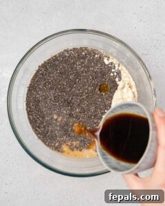 hand pouring coffee in a bowl with yogurt and chia seeds.