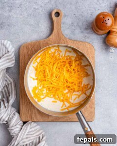 Milk and shredded cheese in a saute pan.
