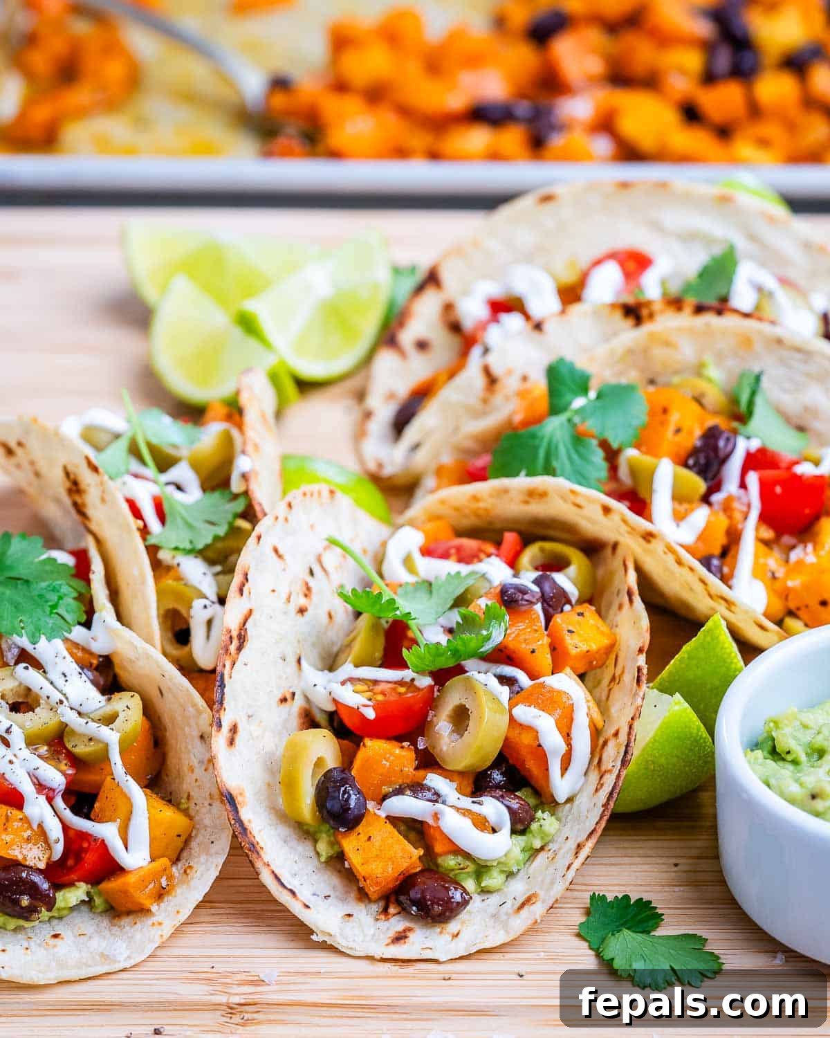 Beautifully assembled Black Bean Sweet Potato Tacos garnished with fresh cilantro and lime wedges, showcasing their vibrant colors and appealing texture.