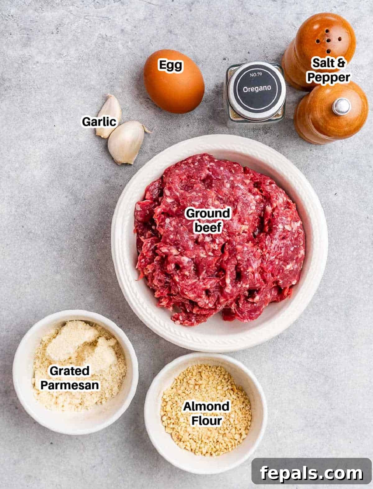 Golden Air Fryer Meatballs 3 A selection of fresh ingredients for air fryer meatballs including lean ground beef, almond flour, parmesan cheese, an egg, garlic, and dried oregano.