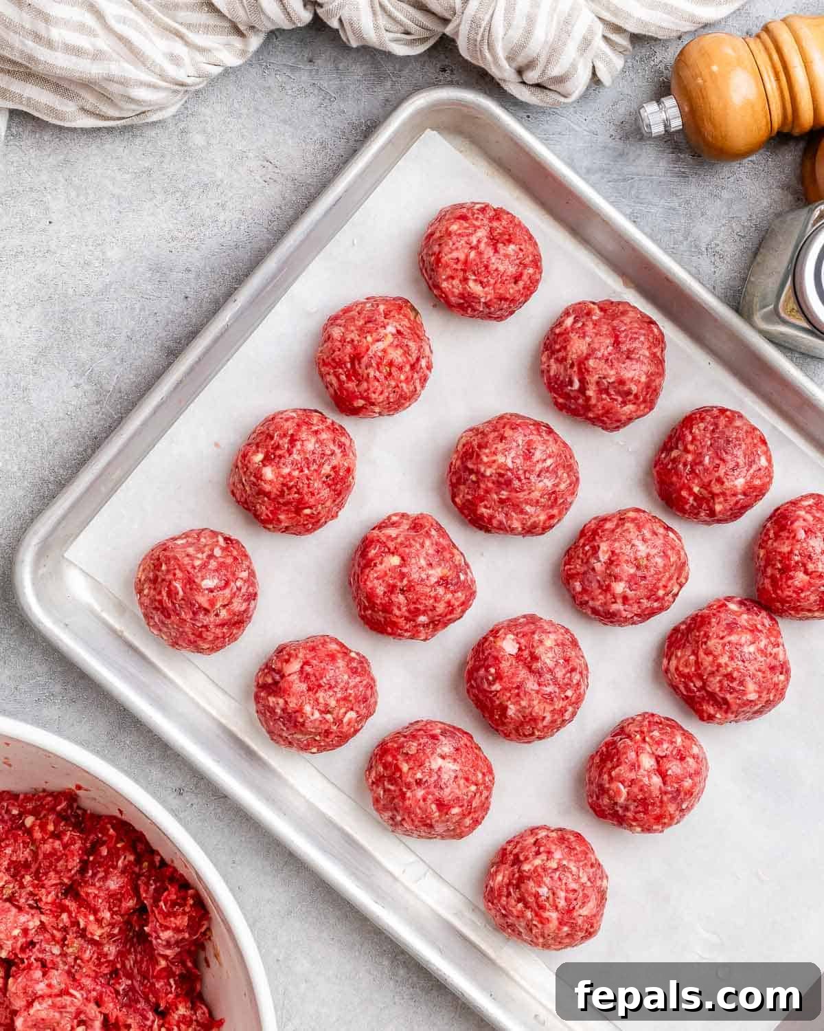 Golden Air Fryer Meatballs 5 Evenly shaped, uncooked meatballs arranged neatly on a baking sheet, ready for the air fryer.