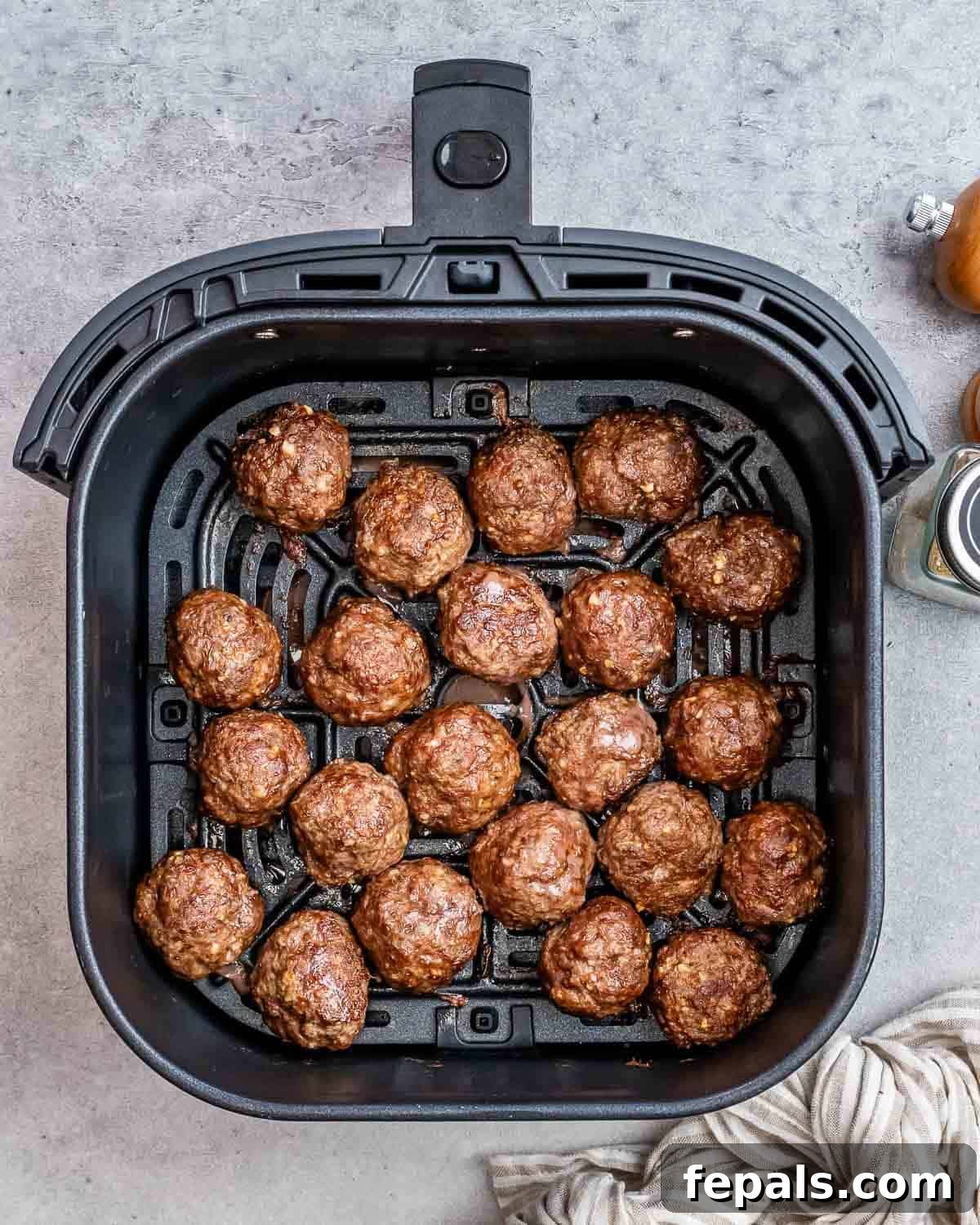 Golden Air Fryer Meatballs 7 An air fryer basket brimming with perfectly cooked, golden-brown meatballs, ready to be served.