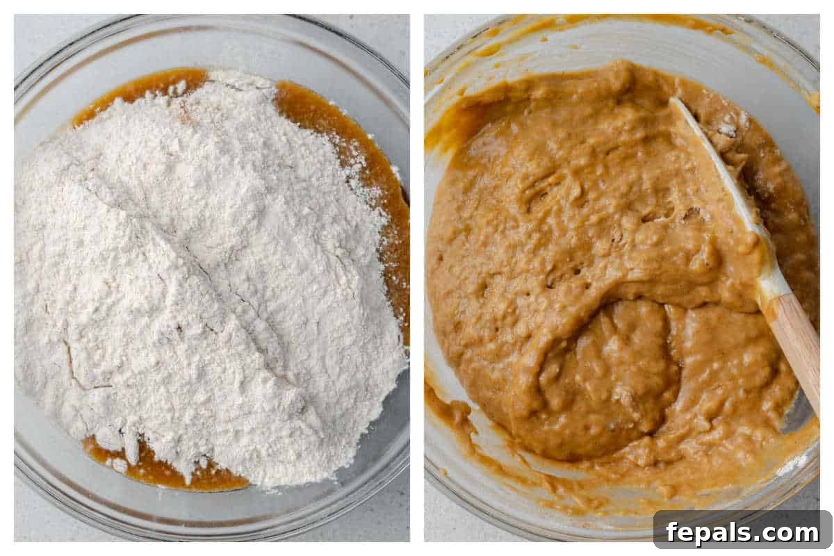 Process shot showing dry flour mixture being added over the wet pumpkin and banana batter, ready for gentle folding with a spatula.