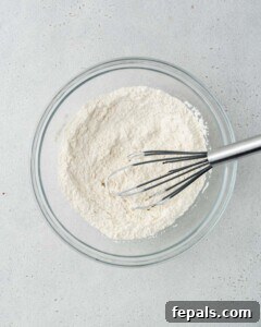 Dry ingredients (flour, baking powder, etc.) are being whisked in a bowl.